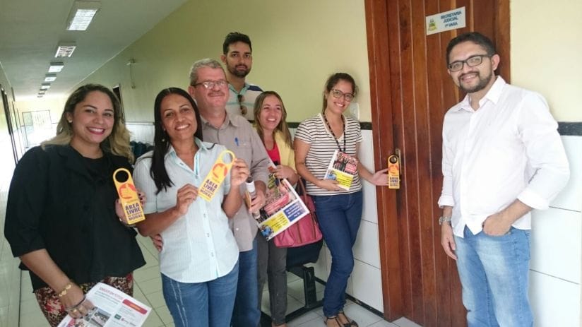 Os servidores colocando aviso de porta contra o assédio moral no fórum de Coelho Neto.