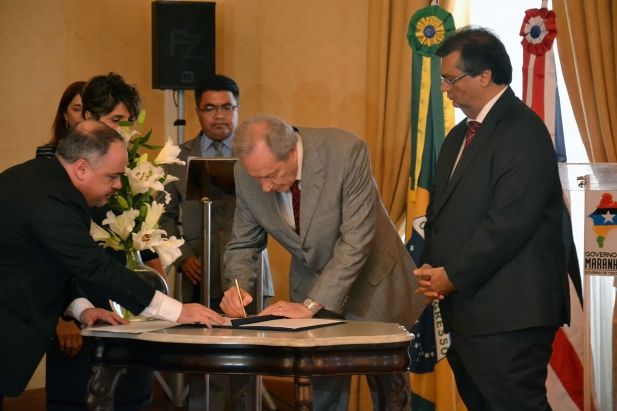 Ministro Lewandowski assina termo sob olhar de governador Flávio Dino.
